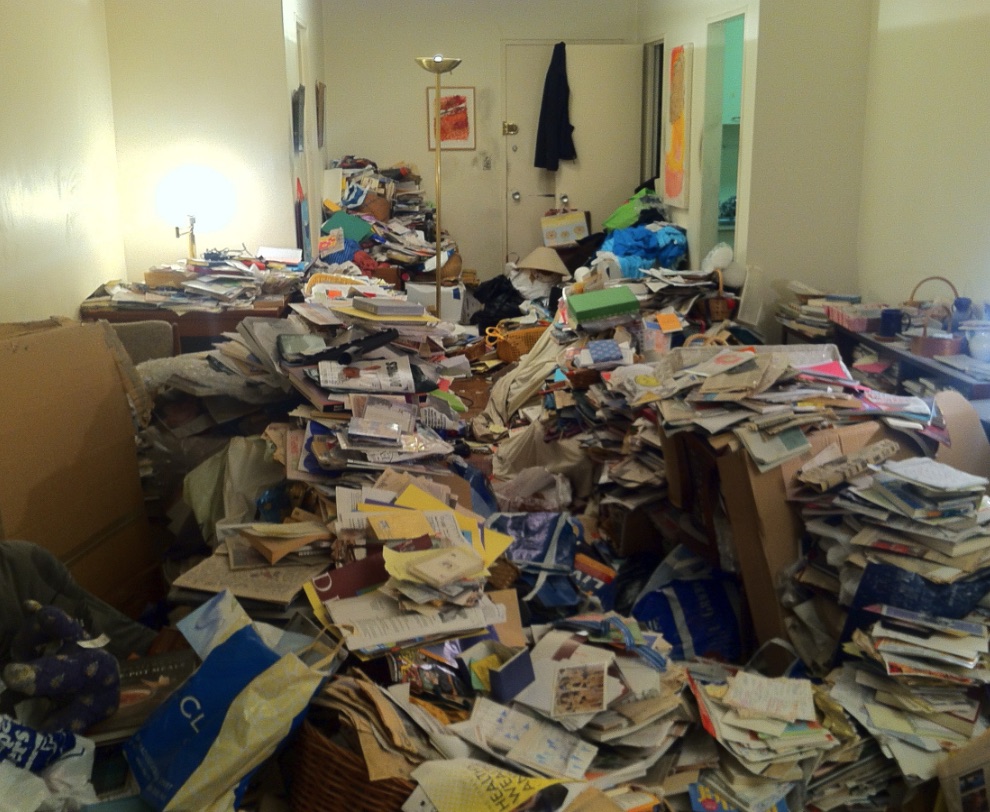 Ferndale apartment room filled with papers, bags, and stacked household items